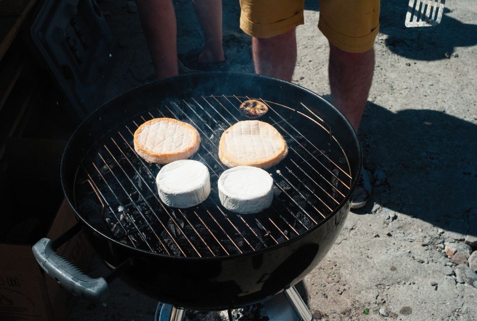 Succulent cheeses being grilled on a charcoal barbecue, perfect for outdoor gatherings.