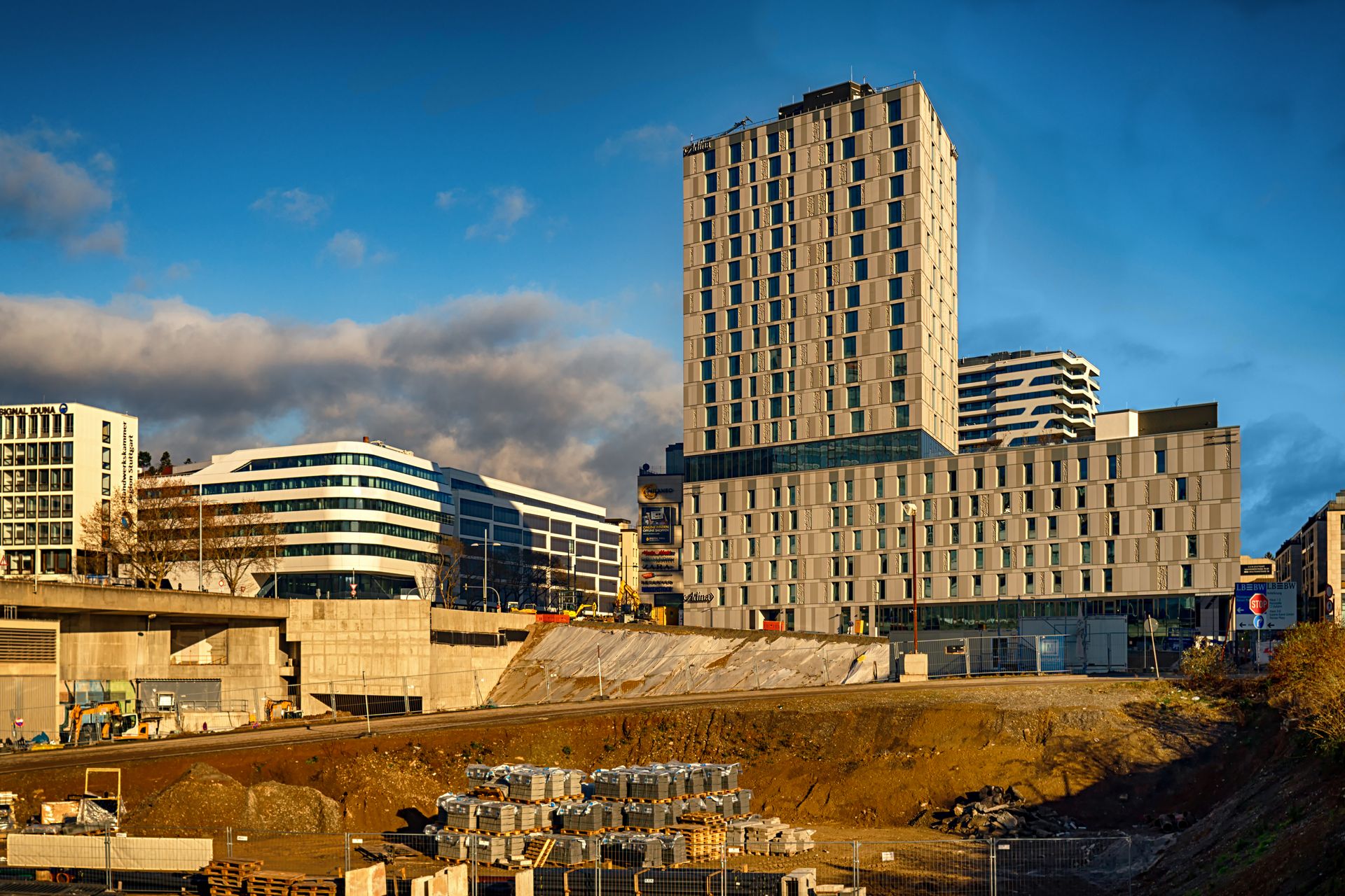 Modern high-rise buildings in Stuttgart with a construction site in foreground under a crisp blue sky.