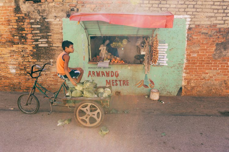 A Boy On A Bicycle By A Store