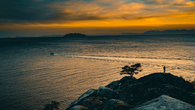 Beautiful sunset captured over the sea with a silhouette on the rocks in West Vancouver, BC.
