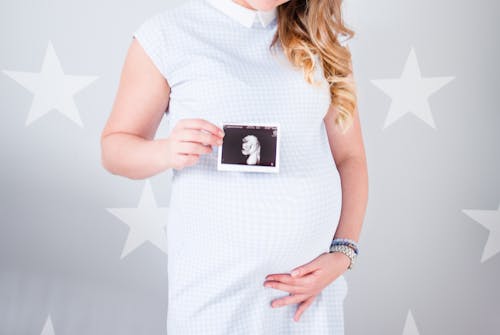 Free Woman Wearing White Cap-sleeved Dress Holding Ultrasound Result Photo Stock Photo