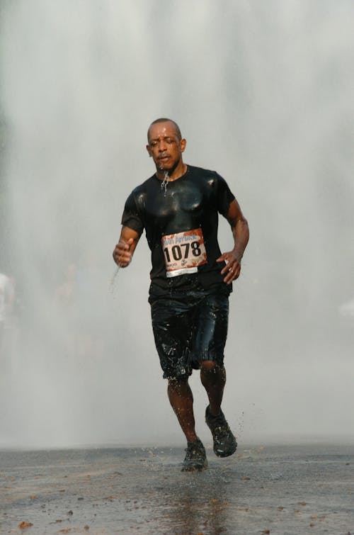 Man in Black Running Under Rain