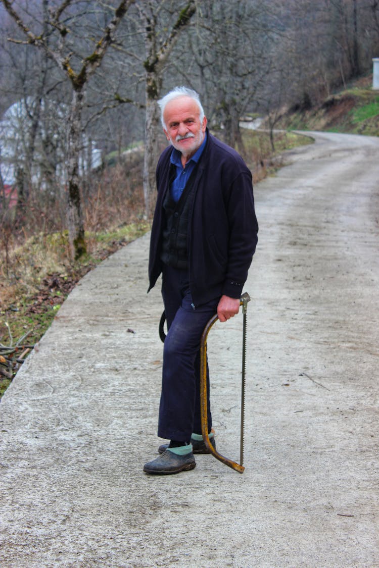 Elderly Man Holding A Saw