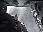 黑白低角度镜头下的现代城市建筑，映衬着戏剧性的天空