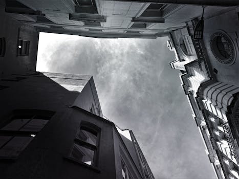 黑白低角度镜头下的现代城市建筑，映衬着戏剧性的天空