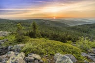 在宁静的自然景观中，捕捉到青山郁郁葱葱、森林茂密的壮丽日落景色