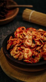Delicious spicy Indonesian crackers served on a rustic plate, perfect for a savory snack. - Fotografer Sidoarjo