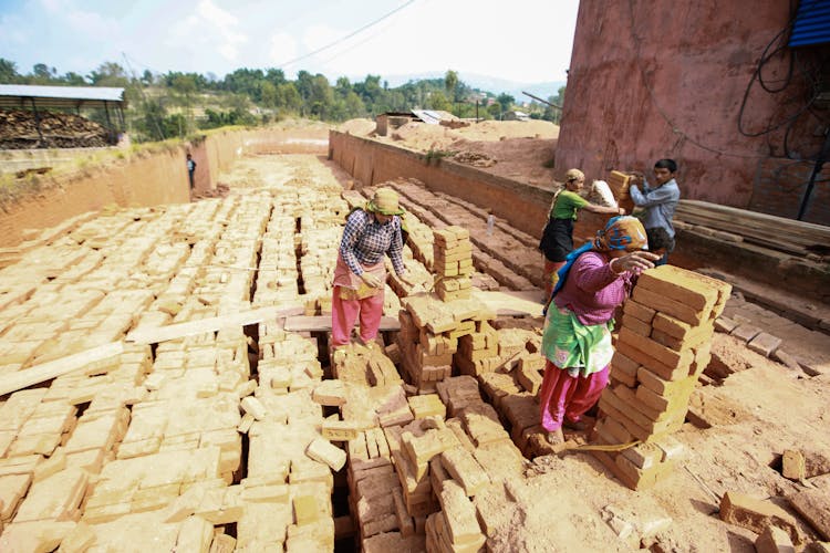 A Group Of People Stacking Bricks