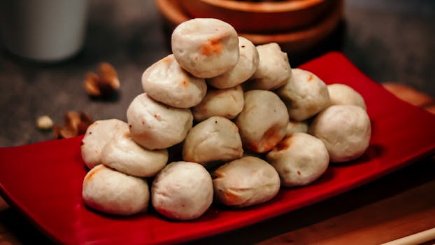 Mouthwatering dumplings stacked on a vibrant red plate, perfect for food lovers.