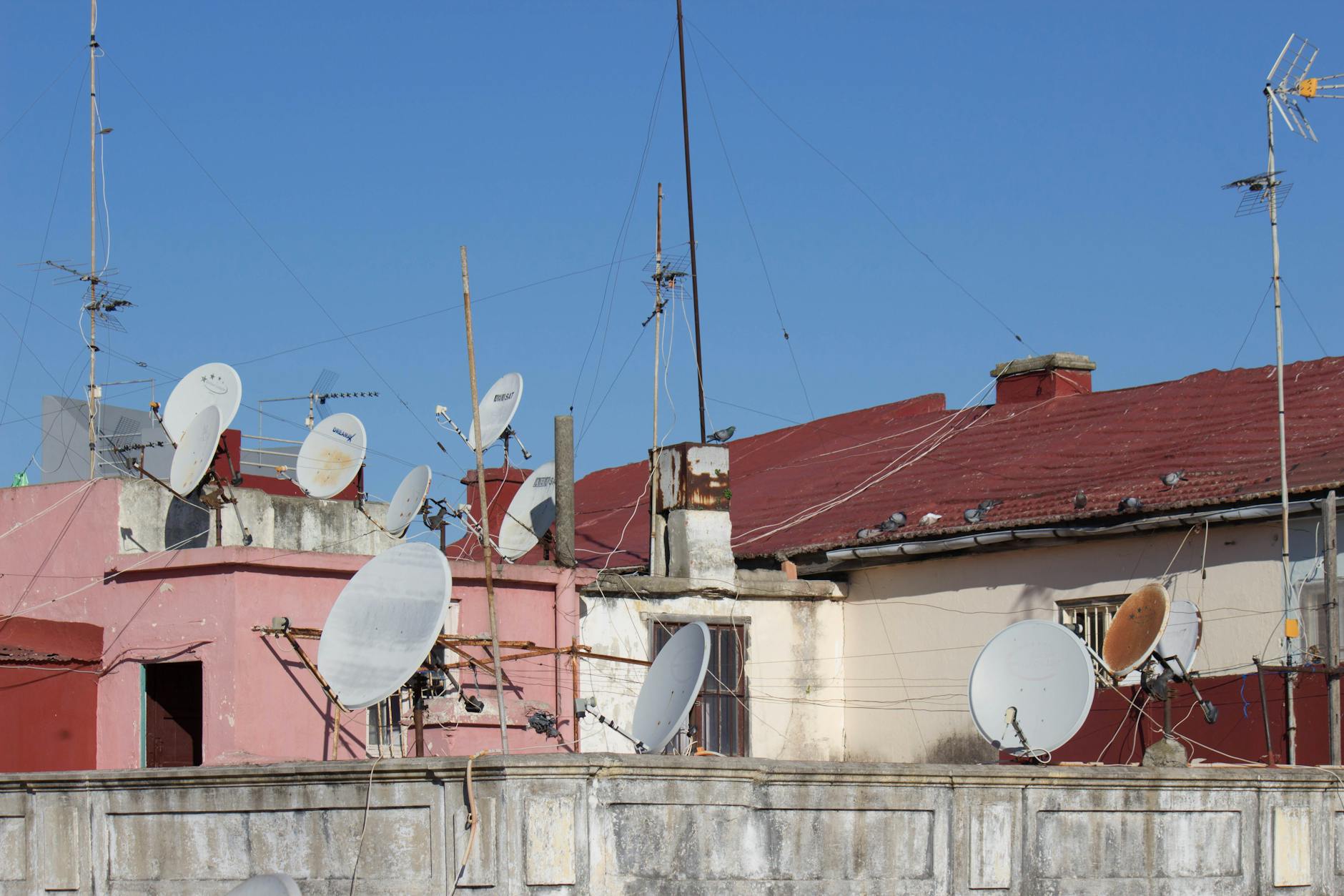Rooftop view of satellite dishes and antennas in Tanger, Morocco, showcasing telecommunication equipment.