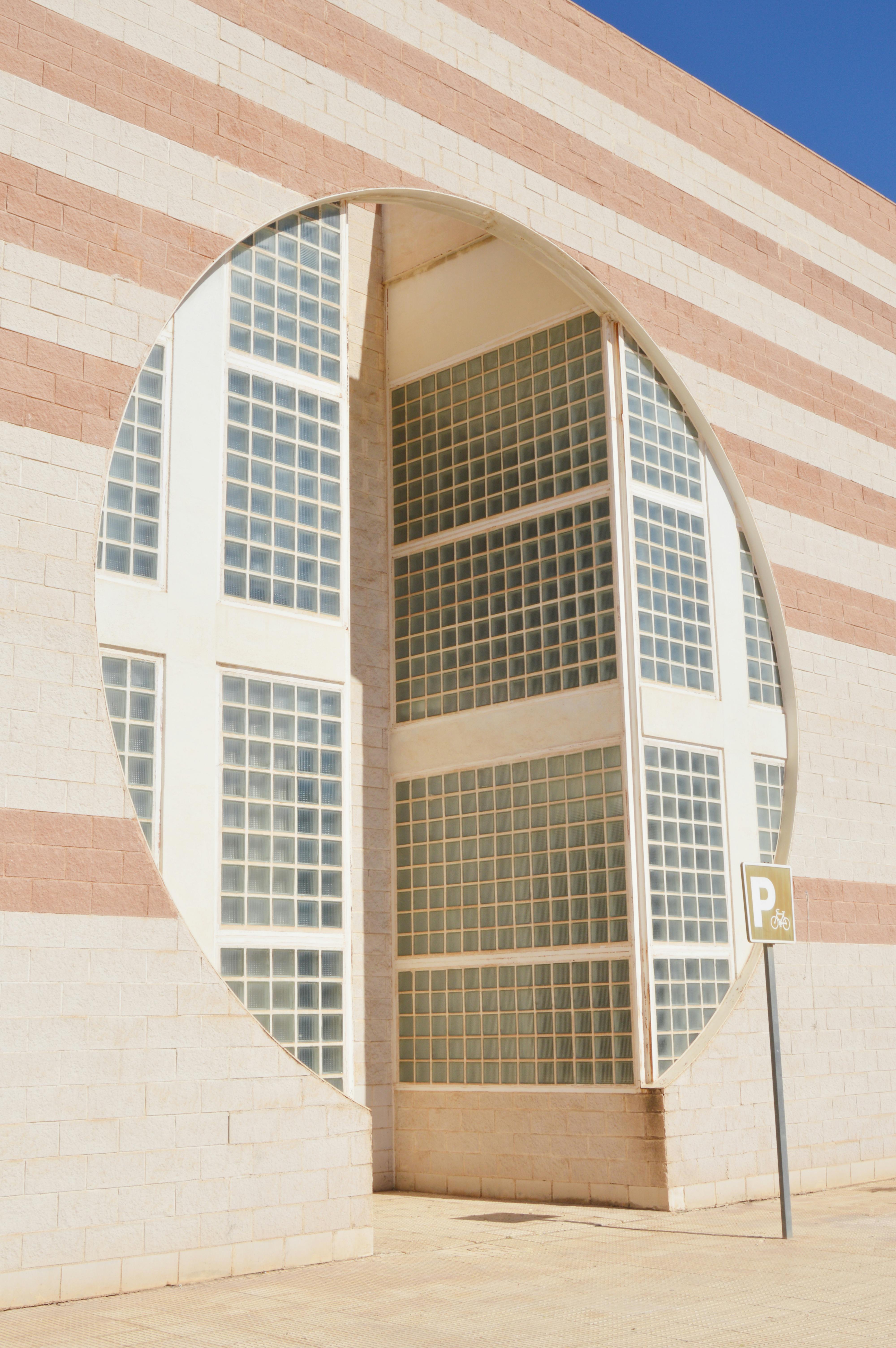Striking architectural facade with glass bricks and circular design in Alicante, Spain.