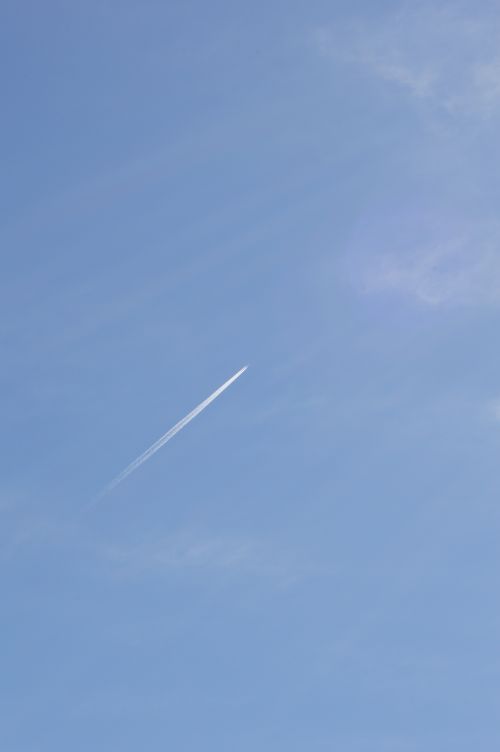 Free A passenger plane leaves a contrail against a clear blue sky over Alicante, Spain. Stock Photo