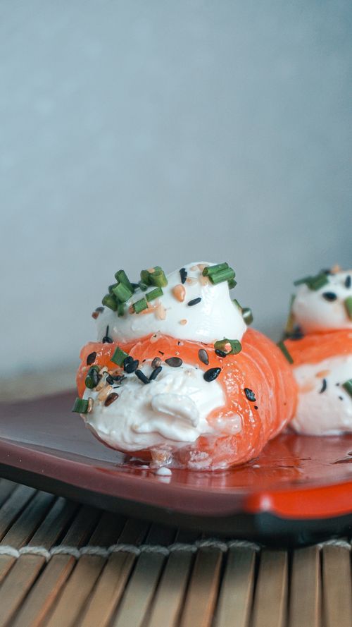 Free Close-up of a gourmet sushi roll topped with cream cheese, chives, and sesame seeds. Stock Photo