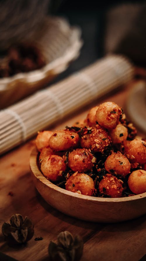 A Set of Fried Ball Shaped Food on a Wooden Bowl