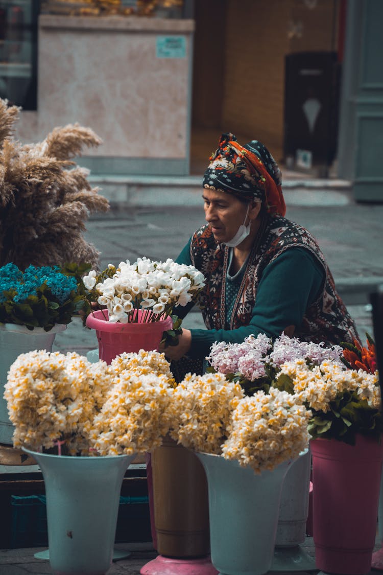 A Woman Selling Flowers On The Street