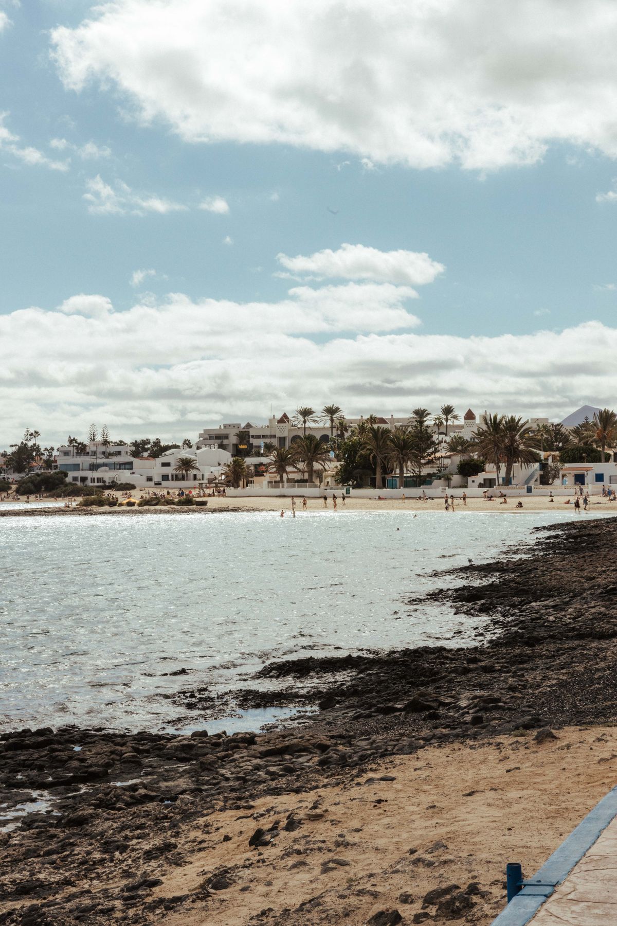 Playa tranquila con casas costeras y palmeras en Lanzarote