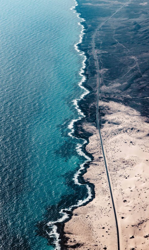 Foto profissional grátis de areia, estrada, litoral
