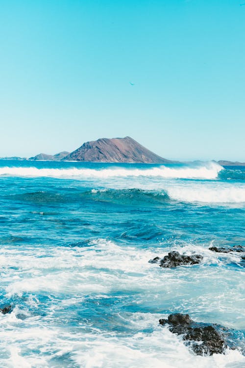 Free Waves on the Shore and View on Volcano  Stock Photo