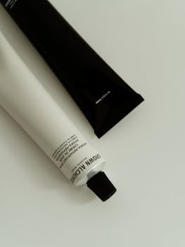 Close-up image of minimalist cosmetic tubes set against a neutral background, emphasizing skincare elegance.