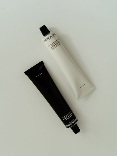 Two minimalist skincare tubes displayed on a white backdrop. Perfect for cosmetic and beauty themes.