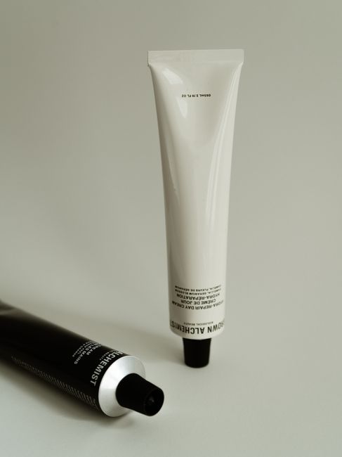 Minimalist photo of skincare product tubes on a neutral background, emphasizing elegance and simplicity.
