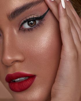 Vibrant close-up portrait featuring bold eye makeup and red lips, highlighting flawless skin.