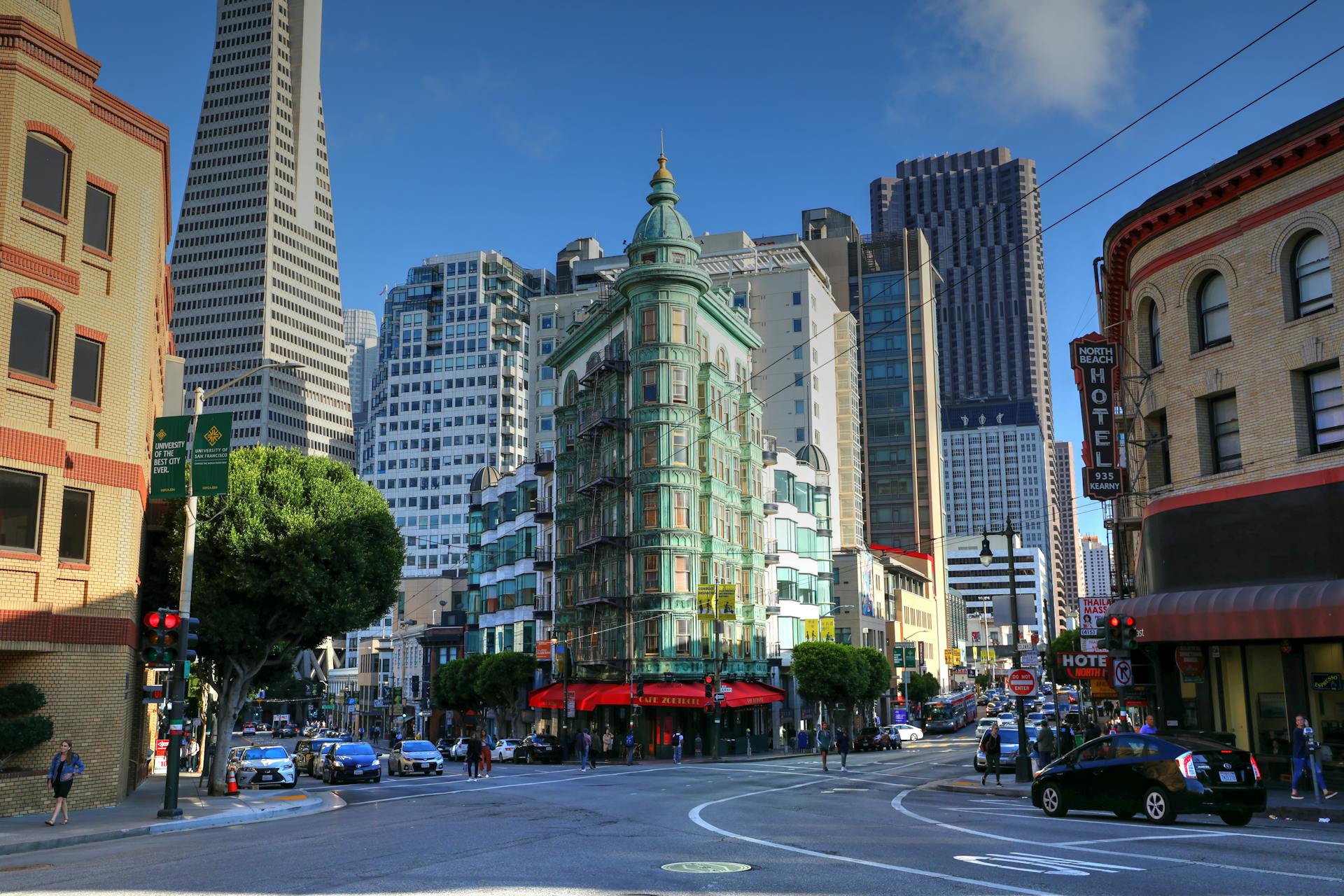 View of San Francisco's Columbus Tower with the Transamerica Pyramid in the background on a sunny day.