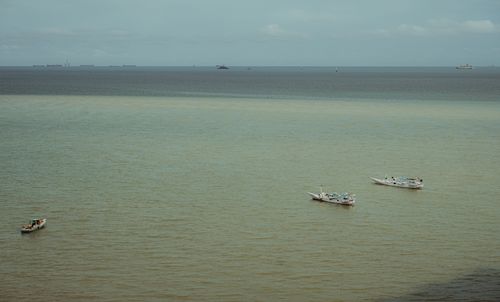 Free A serene view of boats floating on calm sea waters under clear skies. Stock Photo