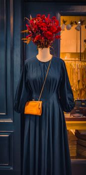 Chic fashion mannequin with dress and floral headpiece, perfect for stylish storefronts.