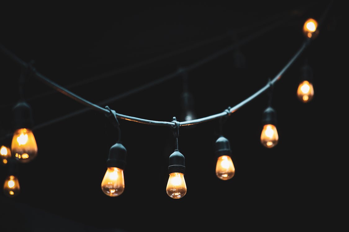 Close-up of a warm glowing string light, adding a cozy and festive atmosphere