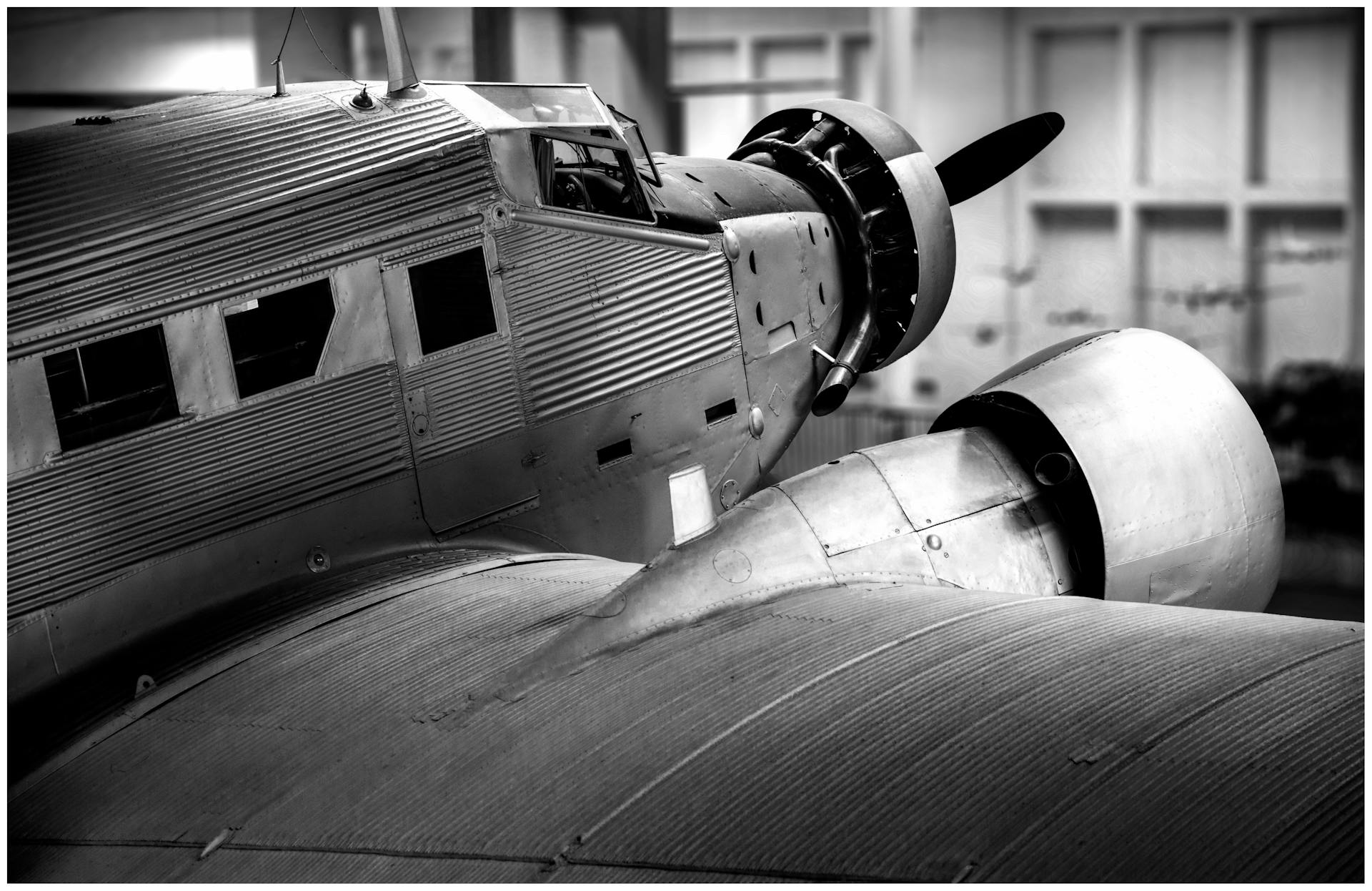 Detailed black and white shot of a classic propeller aircraft engine and fuselage.