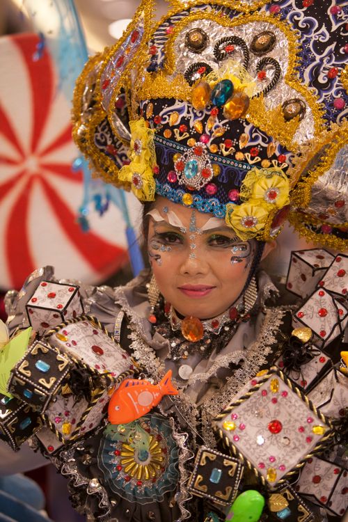 Free An Asian woman in vibrant traditional costume smiles at a cultural festival. Stock Photo