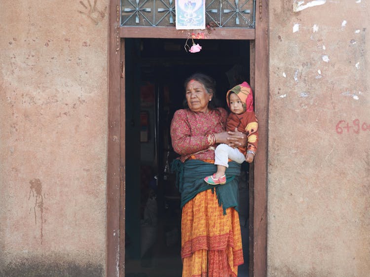 Woman Holding Baby In House Entrance