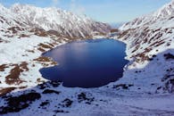 波兰一个宁静的山湖周围，白雪覆盖的山脉呈现出令人叹为观止的冬季景色