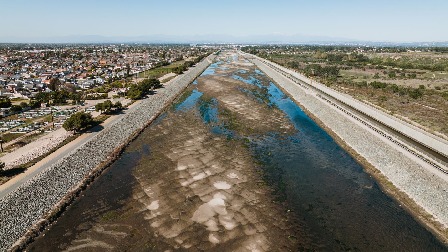 Aerial view of a drought-affected canal in Costa Mesa, highlighting urban landscape and water scarcity.