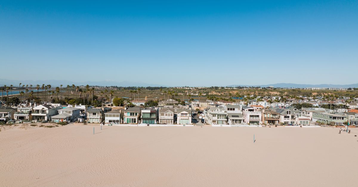 Aerial view of beachfront houses in Newport Beach, CA on a sunny day.