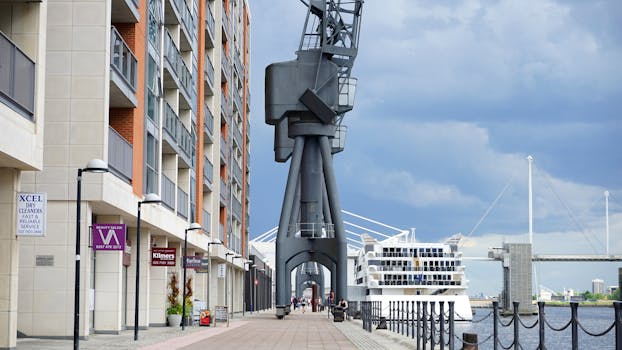 在码头景观中，可以看到一座现代建筑、一台起重机和桥边的一艘船