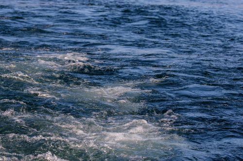 Free Dynamic view of ocean wake creating frothy patterns on the water's surface. Stock Photo