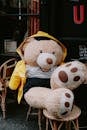 Massive Teddy Bear in Raincoat Seated at Coffee Table Before Cafeteria