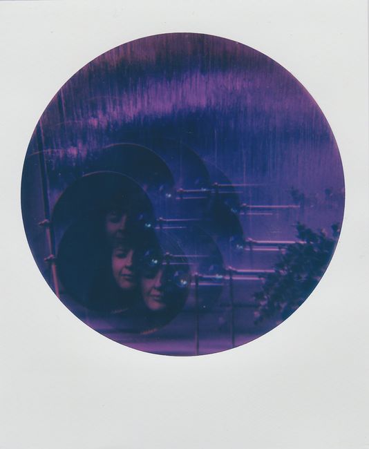 Creative abstract photo featuring multiple exposures in a purple hue within a circular frame.