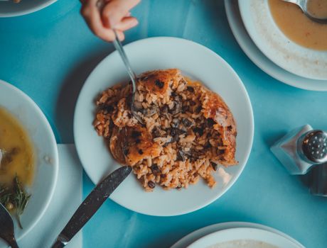 Top view of a savory mushroom risotto being enjoyed at a dining table.