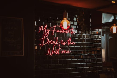 Neon Sign Inside a Bar on Brown Brick Wall