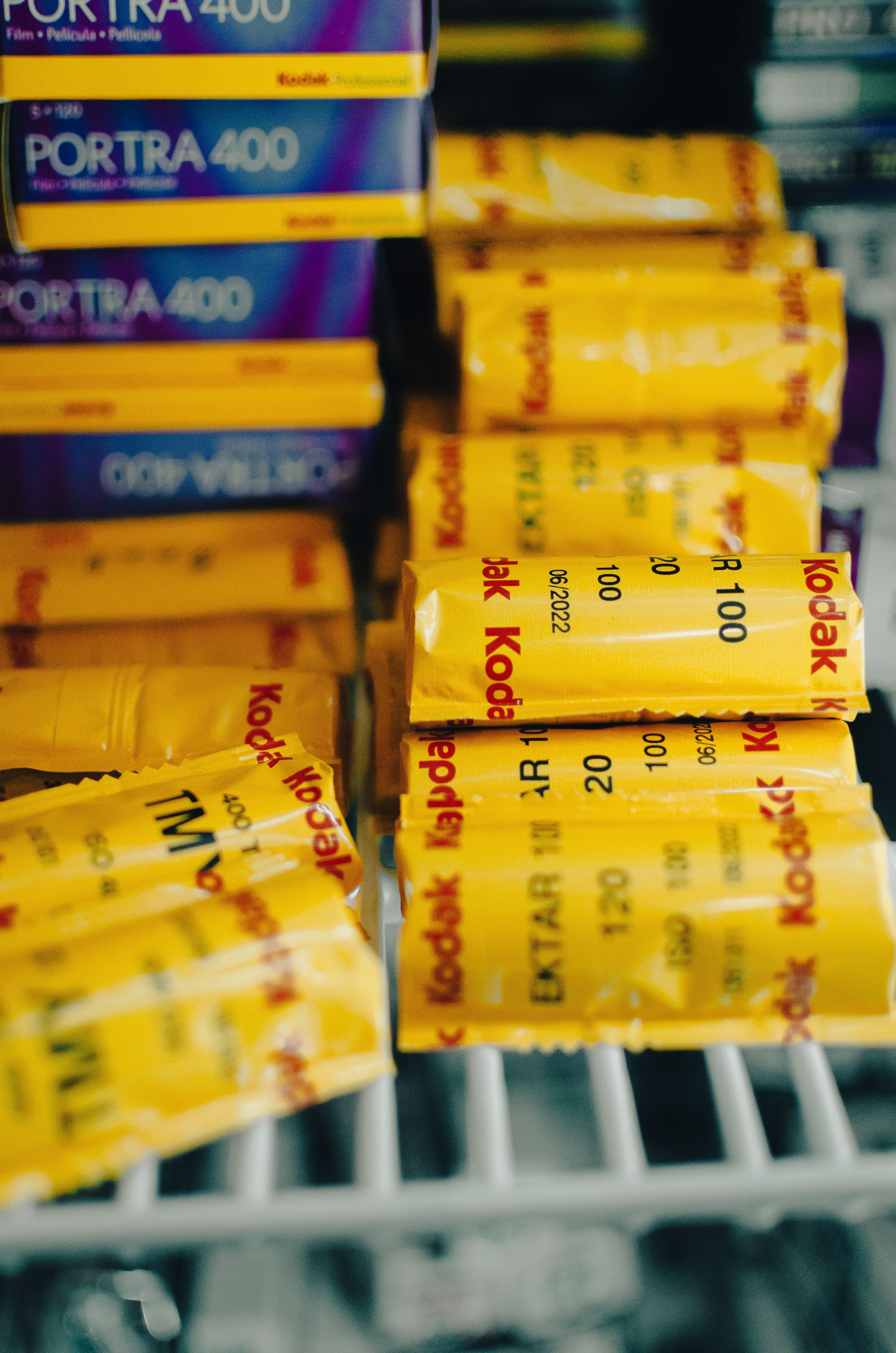 Close-up of stacked Kodak film rolls in storage, showcasing vibrant packaging and classic film photography supplies.