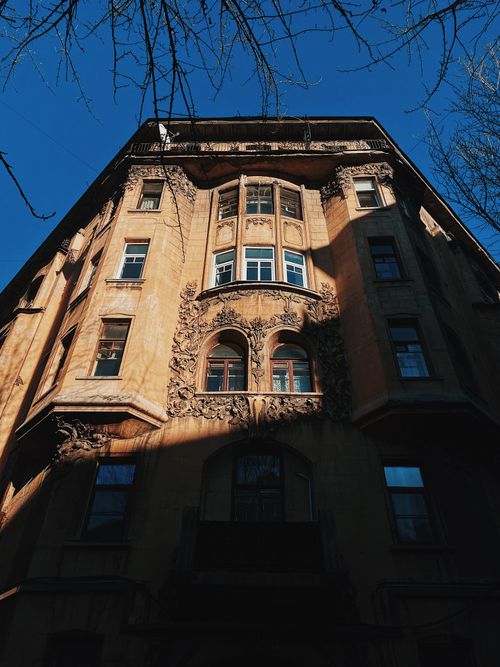 Free Ornate vintage building facade with intricate designs against a bright blue sky. Stock Photo