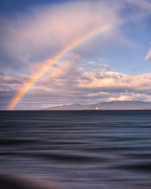 Free Stunning ocean view with rainbow during sunset in British Columbia, Canada. Stock Photo