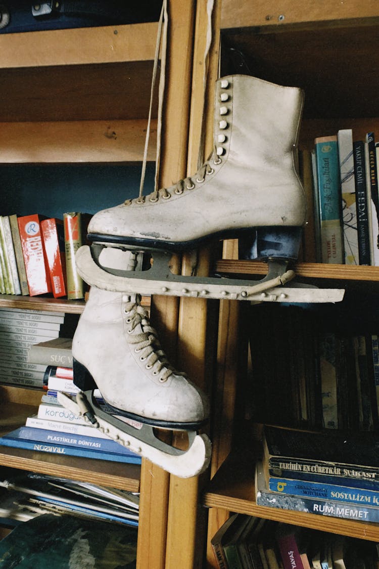 Worn Skates Hanging From Bookshelf