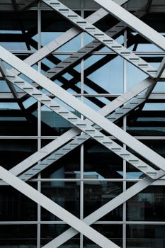 现代建筑物立面上交叉的钢梁和玻璃嵌板的抽象视图
