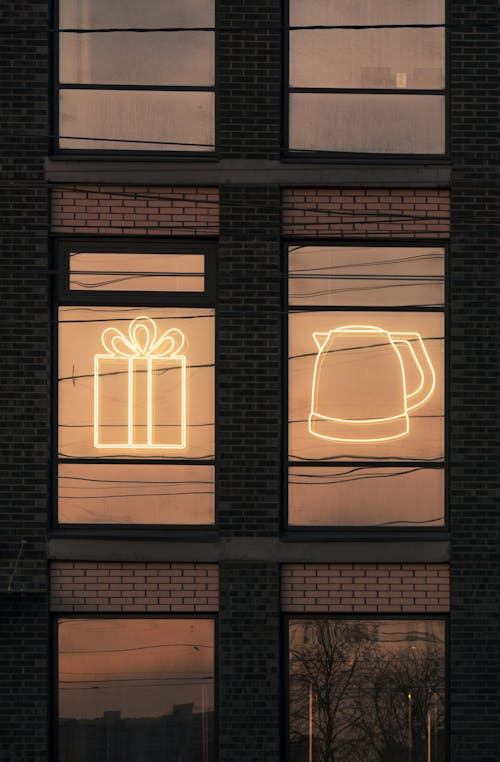 Free Illuminated Neon Lights on a Glass Window of a Brick Building Stock Photo