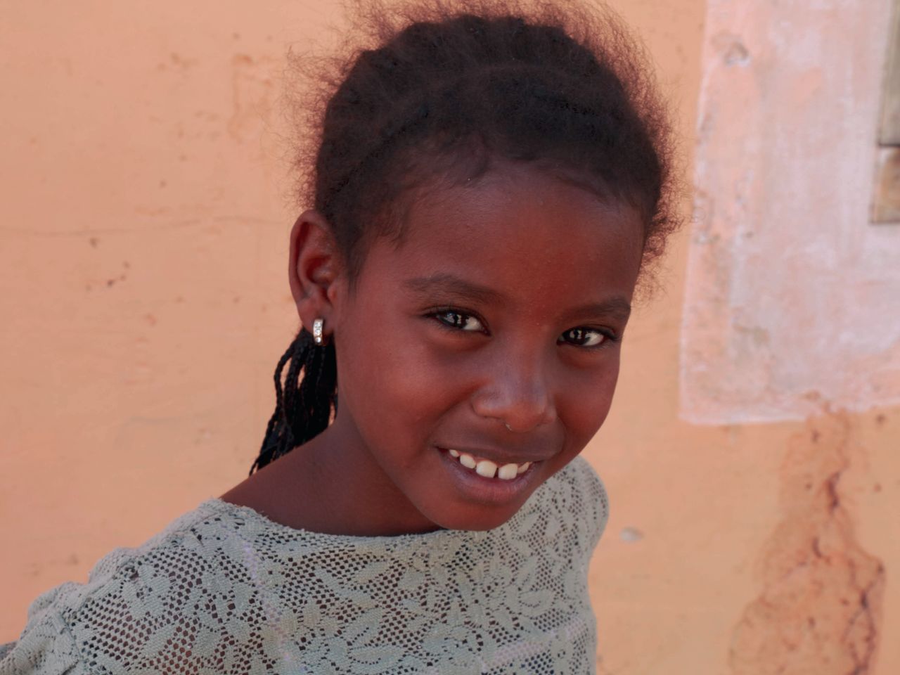 close up portrait of a smiling young girl wearing earrings
