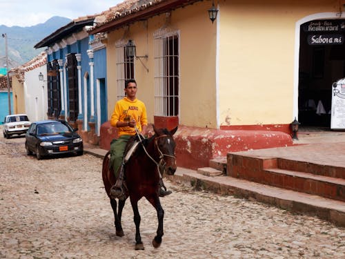 Man in Yellow Sweater Riding Horse
